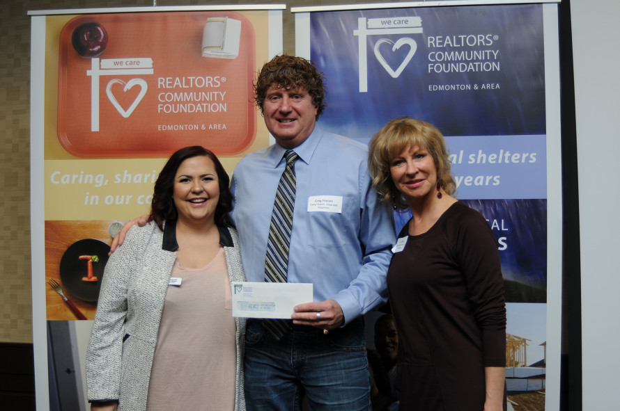 Iris Gillies, left, and Jill Didow, right, of the REALTORS® Community Foundation, present a cheque to Greg Nielsen of Camp Health, Hope and Happiness.