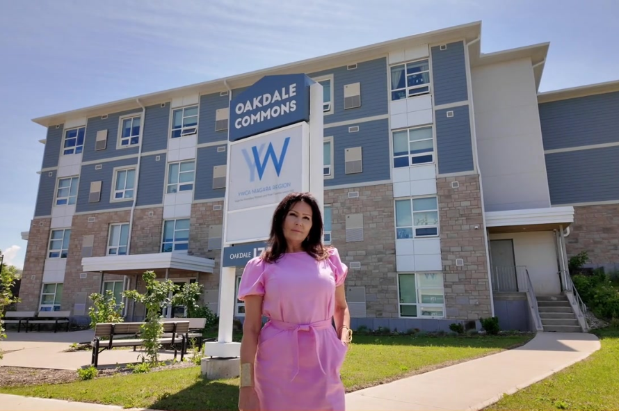 Cindi stands proudly in front of the YWCA Niagara Oakdale Commons Building 